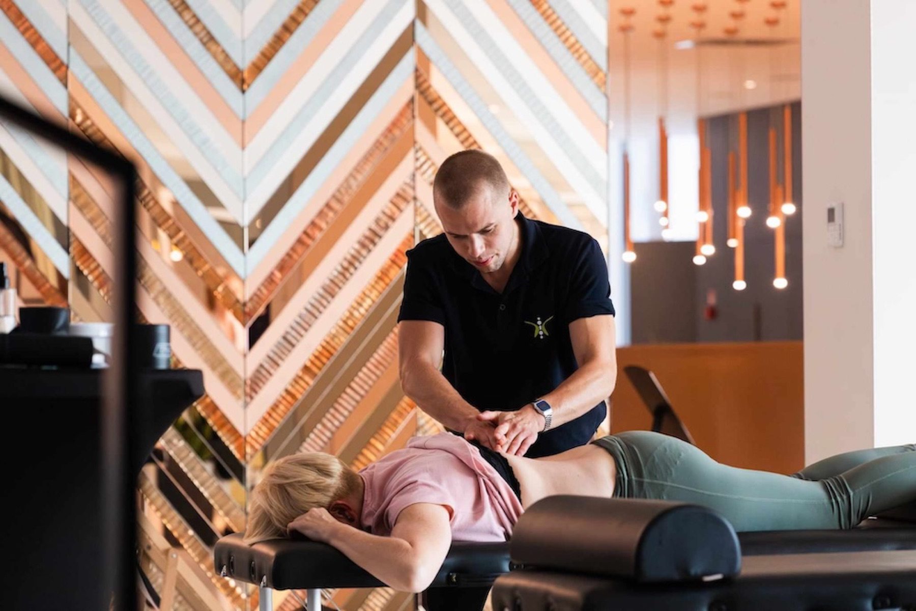 Physiotherapeut behandelt eine Person am Behandlungstisch vor Ort