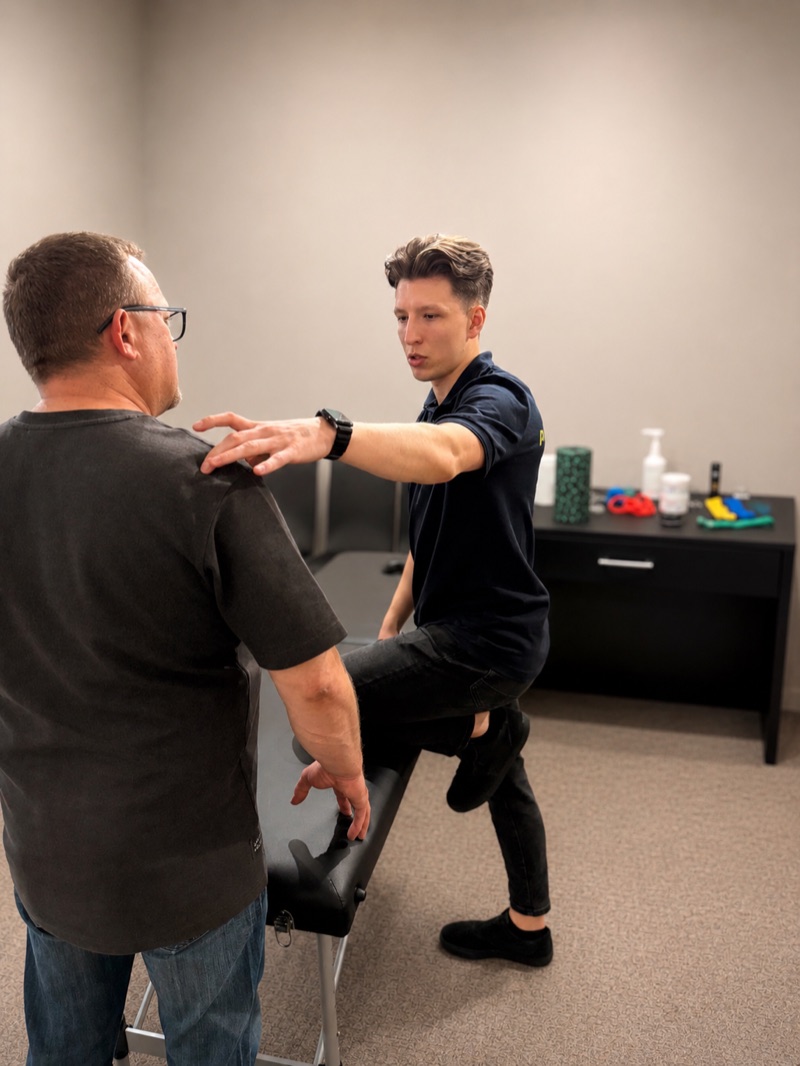 Physiotherapeut Jakub im Gespr&auml;ch mit einem Mitarbeiter am Arbeitsplatz
